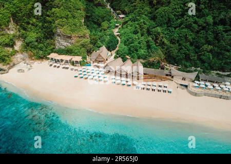 Luftblick auf das Meer und luxuriöses Strandresort mit Sonnenschirmen auf Bali Stockfoto