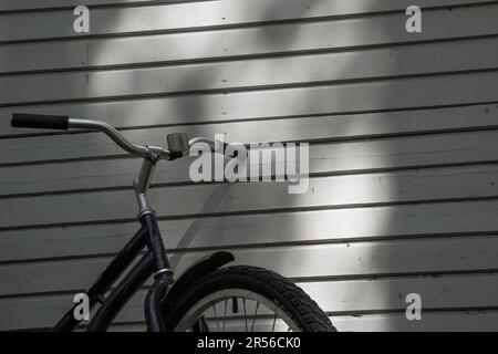 Fahrrad und Schatten auf alter Holzstruktur, Vorder- und Hintergrund verschwommen mit Bokeh-Effekt Stockfoto