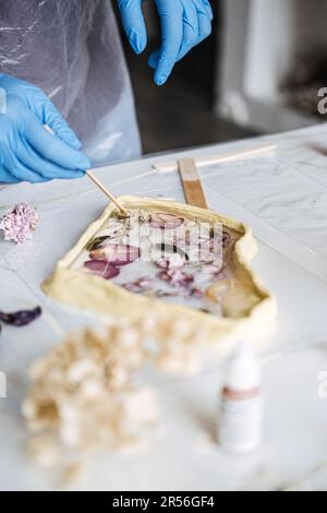 Epoxidharz Art. Kunstgestaltung mit Kunststoff in der Werkstatt. Der Kunstprozess der Herstellung von Epoxidharzhandgefertigten Mitarbeitern im Kunstatelier. Stockfoto