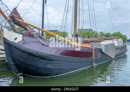 Niederlande. Bewölkter Tag auf dem Amsterdamer Kanal. Altes Frachtschiff am Pier Stockfoto