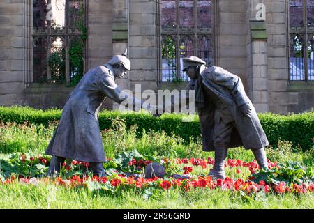 Weihnachtsfriedensstatue mit Fußball und Handschlag vor der zerbombten Kirche. Liverpool UK. Stockfoto