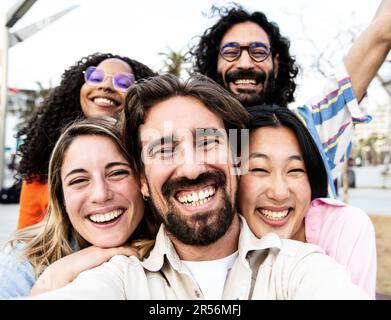 Nahaufnahme einer vielfältigen Gruppe von Freunden, die lächeln und ein Selfie auf der Straße machen. Fröhliche, multiethnische Gruppe junger Hipster, die ein Foto machen Stockfoto