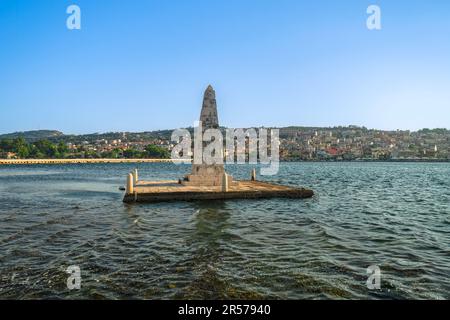 1813 Steinbauten, vom Wasser umgebener Obelisk neben der De Bosset-Brücke mit Argostoli im Hintergrund auf der Ionischen Insel Cephalonia Griechenland. Stockfoto