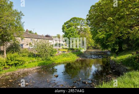 Das kleine Yorkshire Dorf Clapham mit einer historischen Steinbrücke und dem Clapham Beck. Stockfoto