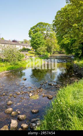 Das kleine Yorkshire Dorf Clapham mit einer historischen Steinbrücke und dem Clapham Beck. Stockfoto