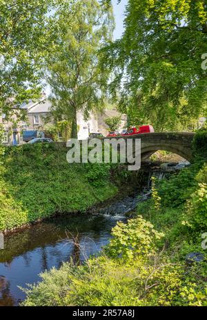 Das kleine Yorkshire Dorf Clapham mit einer historischen Steinbrücke und dem Clapham Beck. Stockfoto