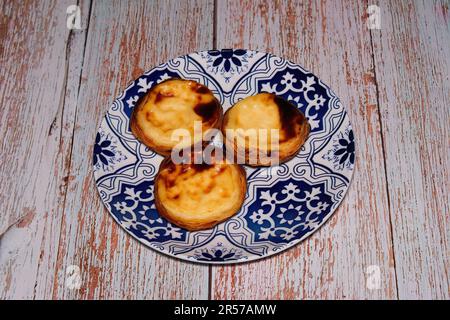 Pasta De Nata, Pastel de Belem, traditionelle portugiesische Pastete mit Eiercreme, serviert auf einem Gericht. Stockfoto