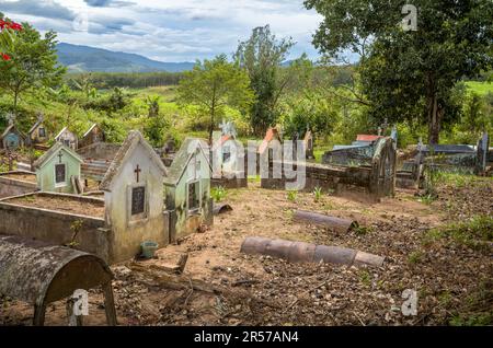 Katholischer Friedhof gegenüber der katholischen Kirche Kon XOM Luh, Kon Ray, Kontum, Vietnam. Ärmere Gräber sind einfach mit rostenden Ölfässern bedeckt. Stockfoto