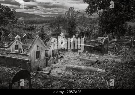 Katholischer Friedhof gegenüber der katholischen Kirche Kon XOM Luh, Kon Ray, Kontum, Vietnam. Ärmere Gräber sind einfach mit rostenden Ölfässern bedeckt. Stockfoto