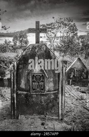 Gräber in einem katholischen Friedhof gegenüber der katholischen Kirche Kon XOM Luh, Kon Ray, Kontum, Vietnam. Ärmere Gräber sind einfach mit rostenden Ölfässern bedeckt. Stockfoto