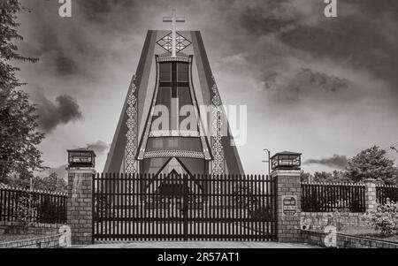 Katholische Kirche Kon Xom Luh, Kon Ray, Kontum, Vietnam. Die Stahltore sind verschlossen. Das Kirchendesign spiegelt die traditionelle ethnische Minderheit des Bahnars wider Stockfoto