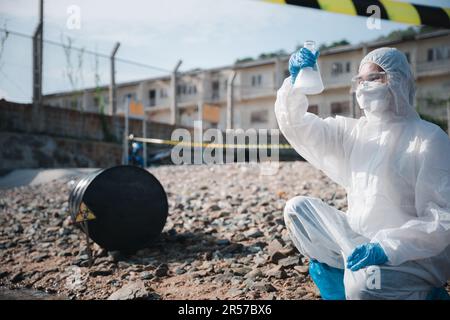 Ökologe entnehmen wassertoxische Chemikalien aus dem Fluss mit Reagenzglas und weisen weißen Rauch auf Stockfoto