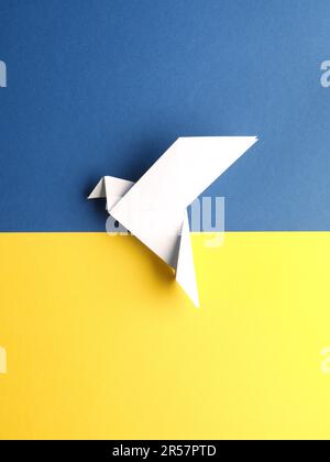 Friedenssymbol mit einer Origami-Taube auf blauem und gelbem Papier als ukrainische Flagge Stockfoto