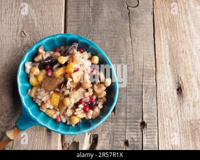 Leckerer Noah s Ark Pudding in einer Creamschüssel, gesundes Müsli auf einem rustikalen Holztisch, frisches und traditionelles Bio-Food-Konzept Stockfoto