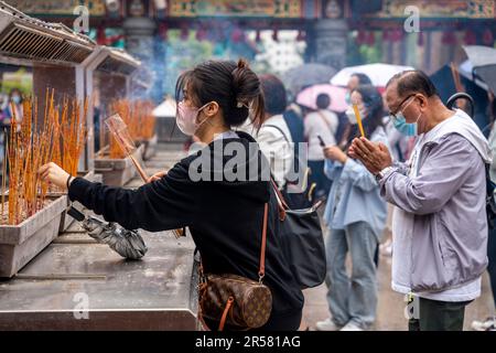 Junge Chinesen Beten Im Wong Tai Sin Tempel An, Hongkong, China. Stockfoto