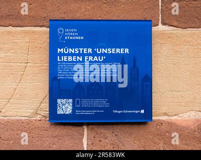 Villingen-Schwenningen, Deutschland - 30. April 2023: Ein blaues Brett mit einer kurzen Geschichte der mittelalterlichen Kirche St. Mary - unsere Frau von Villingen in Bad W. Stockfoto