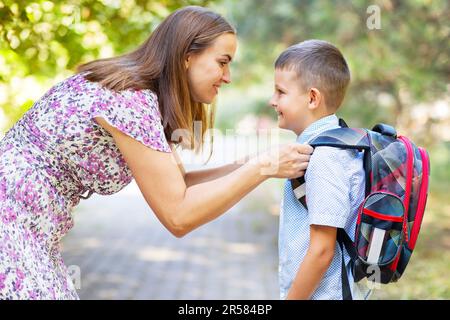 Zurück zur Schule. Mutter sagt ihrem Sohn Auf Wiedersehen, als er zur Schule geht Stockfoto