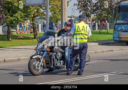 Der Polizist hält Biker wegen Verkehrsverstößen an. Motorradfahren ohne Schutzhelm. Dnipro, Ukraine - 13. September 2014 Stockfoto