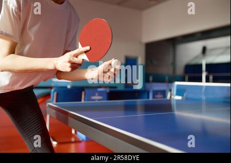 Nahaufnahme einer erwachsenen Frau, die Tischtennis im Fitnessstudio spielt Stockfoto