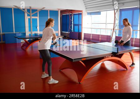 Mann und Frau spielen Tischtennis drinnen Stockfoto