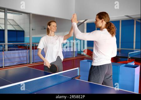 Männliche und weibliche Tennisspieler geben sich gegenseitig High-Five Stockfoto