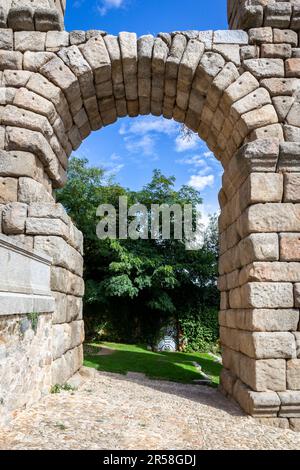 Arch des Aquädukts von Segovia, Spanien, altes römisches Steinbauwerk, Symbol von Segovia mit üppiger grüner Vegetation. Stockfoto