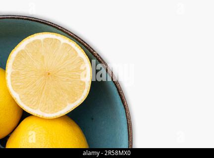 Halb geschnitten und ganze Zitronen in einer Schüssel. Nahaufnahme, Konzept, niemand. Stockfoto