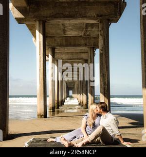 Glückliches, liebevolles Paar unter dem Pier. Stockfoto