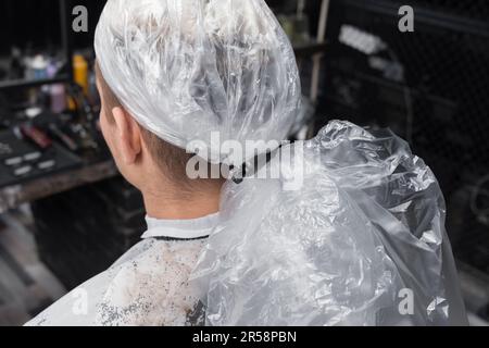 Barbershop-Client-man-Nahaufnahme im professionellen Haarfärbeverfahren mit Plastikfolie. Stockfoto