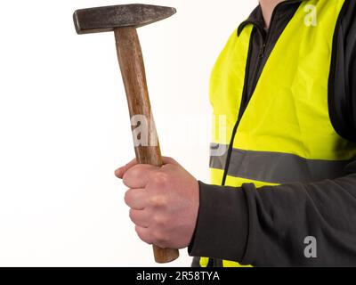 Ein Arbeiter in einer Sicherheitsweste hält einen Hammer in der Hand. Kein Gesicht, weißer Hintergrund, Kopierraum. Stockfoto