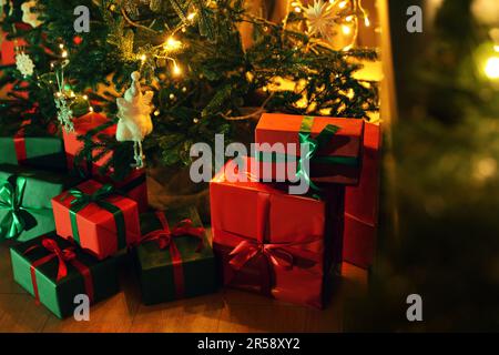 Wunderschön verpackte Geschenkboxen unter dem Weihnachtsbaum drinnen Stockfoto