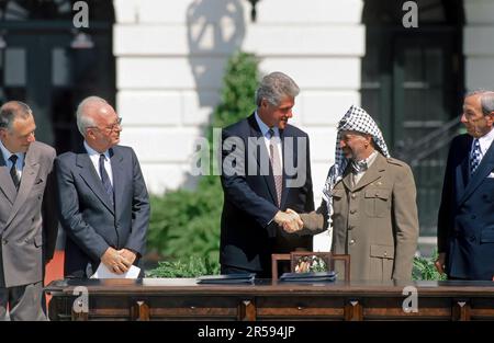 WASHINGTON DC - 13. SEPTEMBER 1993 US-Präsident William Jefferson Clinton schüttelt die Hand mit PLO-Vorsitzender Yasser Arafat, während US-Außenminister Warren Christopher (R), russischer Außenminister Andrei Kozyrev und israelischer Premierminister Yitzhak Rabin (L) zusehen. Die politischen Führer hatten sich auf dem südlichen Rasen des Weißen Hauses versammelt, um das Nahost-Friedensabkommen zwischen Israel und der PLO zu unterzeichnen. Stockfoto