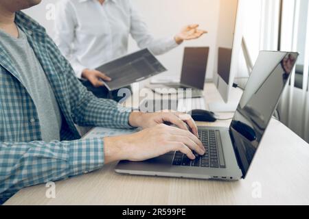 Zwei Partnerschaften entwickeln Programmierungs- und Codierungstechnologien, arbeiten am Laptop und analysieren gemeinsam. Stockfoto