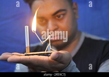 Bijoy Debnath, ein 21-jähriger Künstler, der sein Kunstwerk mit Streichholzstäbchen und Zigaretten zeigt, das einen Streichholzmann darstellt, der eine Zigarette mit einem Schwert tötet, als Teil einer Kampagne zum Aufgeben des Rauchens am Vorabend des Weltnotrauchtags. Der 31. Mai wird als Weltnotrauchtag gefeiert, um weltweit das Bewusstsein für den Tabakkonsum zu schärfen. Agartala, Indien. Stockfoto