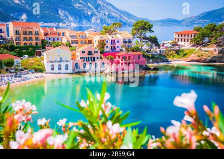 Assos, Griechenland. Malerisches Dorf auf den idyllischen Inseln Cephalonia. Wunderschöne farbenfrohe Häuser und türkisfarbene Bucht. Stockfoto