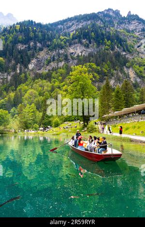 Touristen machen eine Bootsfahrt auf dem Blausee Lake (Blue Lake), Schweiz Stockfoto
