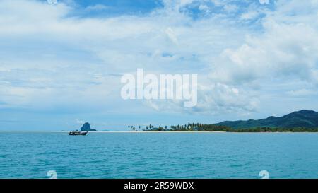 Panoramablick auf das Meer von Phuket, Insel Naka Yai mit weißem Sandstrand. Berg auf der Insel als Horizont und ein kleines Fischerboot. Stockfoto