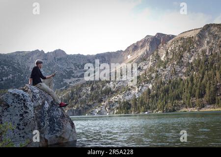 Ein Mann liest am Star Lake in den Sierra Nevada Mountains Stockfoto