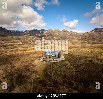 Kleines verwittertes Haus auf einer Wiese in den Bergen Stockfoto