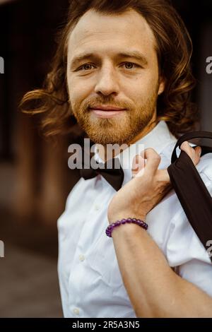 Ein junger Mann mit weißem Hemd und Fliege in der Stadt. Stockfoto