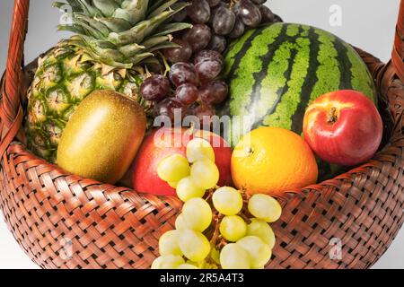 Detailansicht des Obstkorbs gefüllt mit frischem und köstlichem Obst. Gefüllt mit Ananas, Kiwi, Trauben, Äpfeln, Orange, Nektarine und Melone. Stockfoto