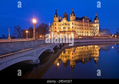 Beleuchtetes Schloss Schwerin mit der Schlossbrücke zur Schlossinsel am Abend, Deutschland, Mecklenburg-Vorpommern, Schwerin Stockfoto