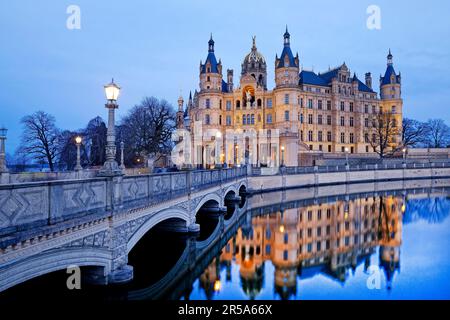 Beleuchtetes Schloss Schwerin mit der Schlossbrücke zur Schlossinsel am Abend, Deutschland, Mecklenburg-Vorpommern, Schwerin Stockfoto