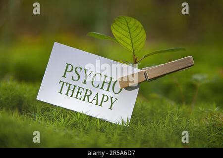 Seedling auf einer Wiese mit einem Stück Papier zur Psychotherapie Stockfoto