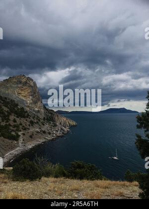 Vertikaler Fotoblick auf das Meer vom Berg, wolkiger Himmel. Stockfoto
