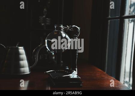 Vakuumkaffeemaschine auf Holztisch im Café Stockfoto