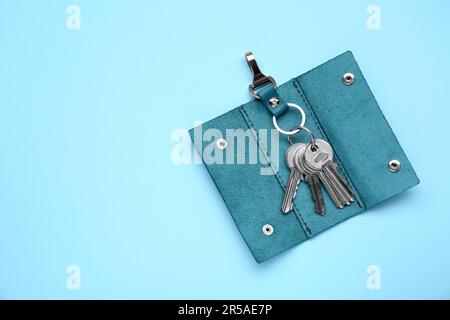 Lederhalter mit Tasten auf hellblauem Hintergrund, Draufsicht. Platz für Text Stockfoto