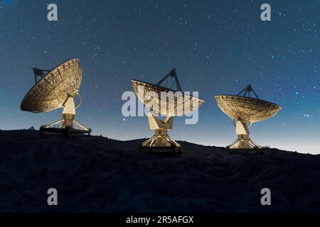 Satellitenschüsseln auf dem Gipfel des Hügels bei Nacht. Signalsuche im Raumbeobachtungszentrum. Radioastronomie-Observatorium. Fantastische Nachthimmel Landschaft mit anten Stockfoto