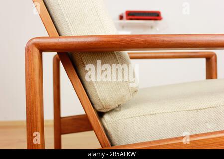 Sessel mit osmanischem dänischem Design in einem gemütlichen, modern eingerichteten Wohnzimmer im Stil 60s mit Wandablage und Schreibmaschine im Hintergrund-Ora Stockfoto