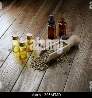 Bild von Cannabisöl auf einem Tisch. Ätherische CBD-Öle in kleinen Glasflaschen neben Hanfsamen in einem Holzlöffel. Konzept von Therapie und Kosmet Stockfoto